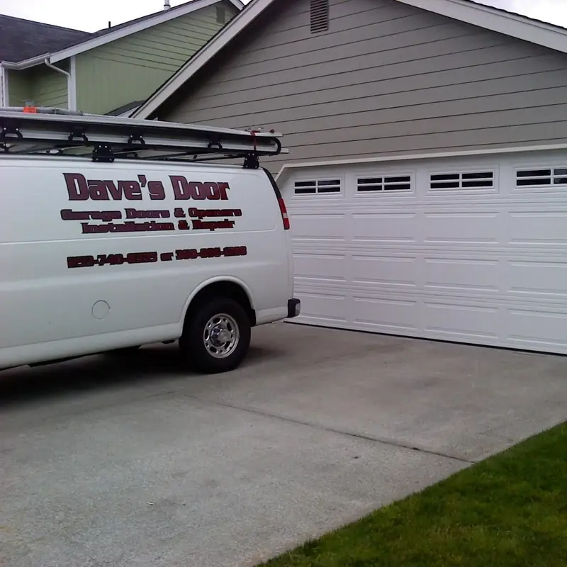 The Dave's Door van parked beside a newly installed white garage door