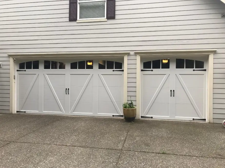 White carriage house style double garage doors installed on a Pacific Northwest home
