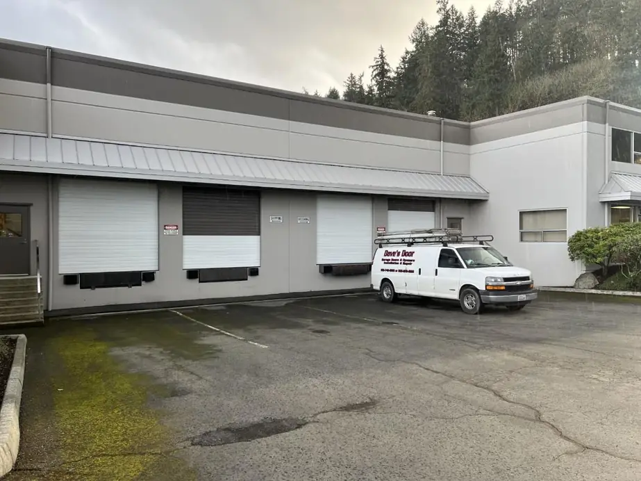 The Dave's Door van at a commercial loading dock with roll up doors